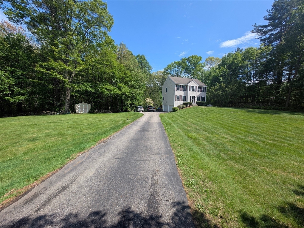83 Haggerty Road Charlton, MA 01507 - Photo 23 of 32 a front view of a house with a yard and trees
