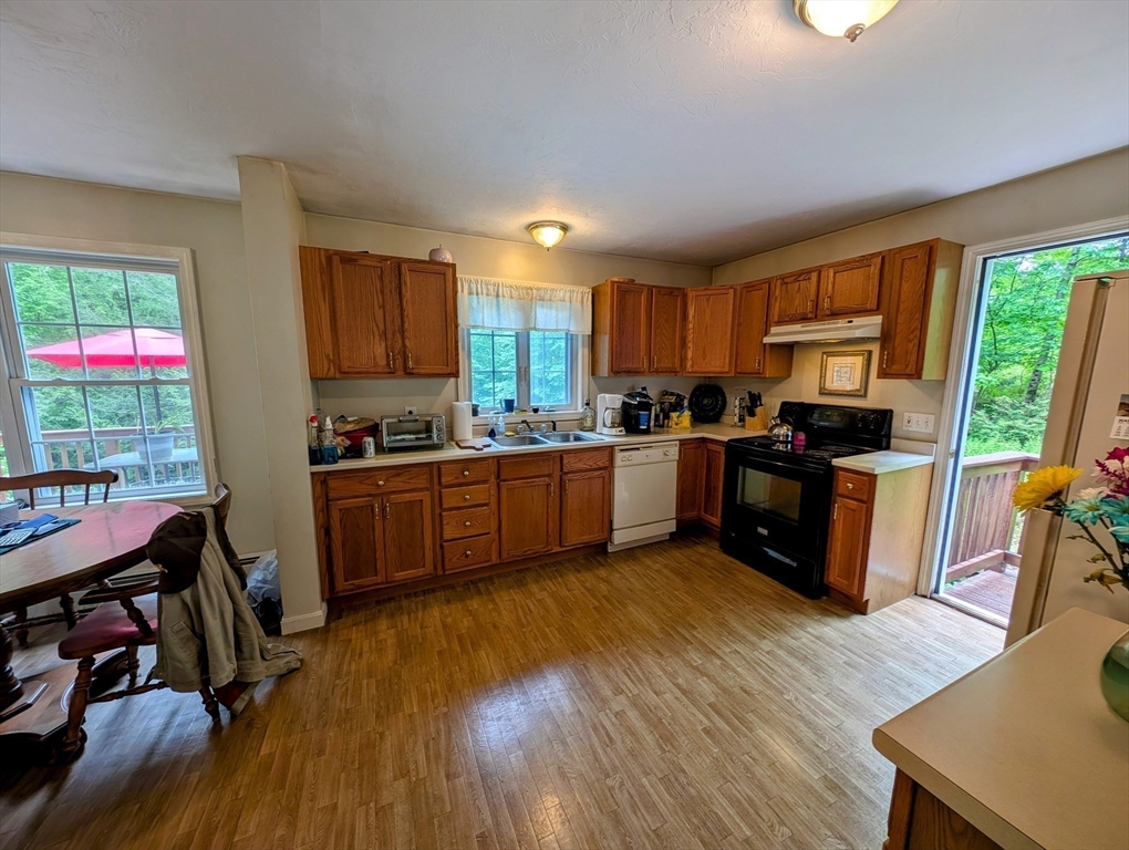 83 Haggerty Road Charlton, MA 01507 - Photo 3 of 32 a kitchen with stainless steel appliances wooden floors and wooden cabinets
