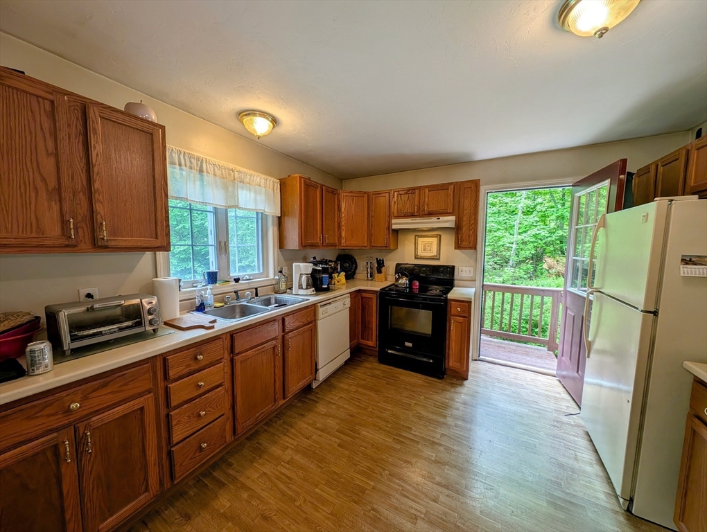83 Haggerty Road Charlton, MA 01507 - Photo 9 of 32 a kitchen with sink a refrigerator and wooden cabinets
