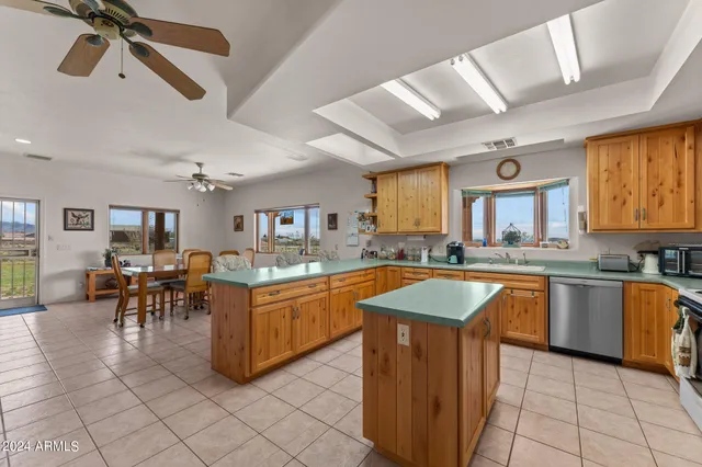 a large kitchen with stainless steel appliances granite countertop a sink counter space cabinets and a large window