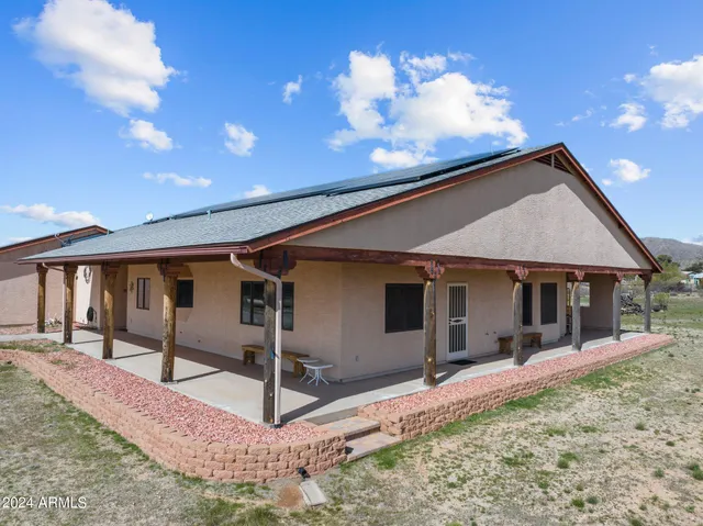 a view of a house with large windows and wooden fence