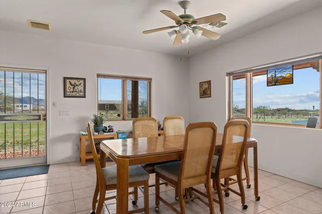 a dining area with stainless steel appliances kitchen island granite countertop furniture and a large window