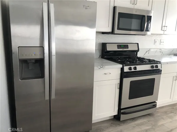 a kitchen with white cabinets sink and stainless steel appliances