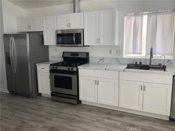 a kitchen with stainless steel appliances wooden cabinets and a stove top oven