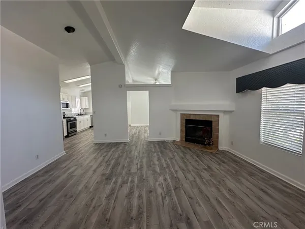 a view of empty room with wooden floor and fireplace