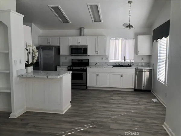 a kitchen with stainless steel appliances wooden cabinets and a stove