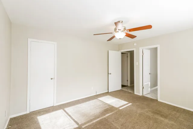 a view of a room with a ceiling fan and a window