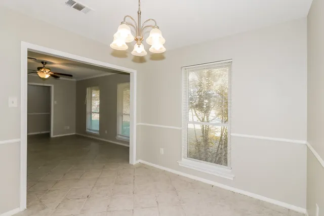en view of an empty room with a chandelier fan