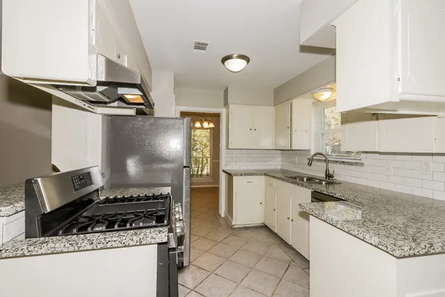 a kitchen with a sink stove and cabinets