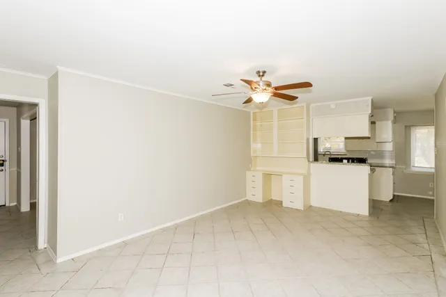 a view of a kitchen with a sink and dishwasher a refrigerator with white cabinets