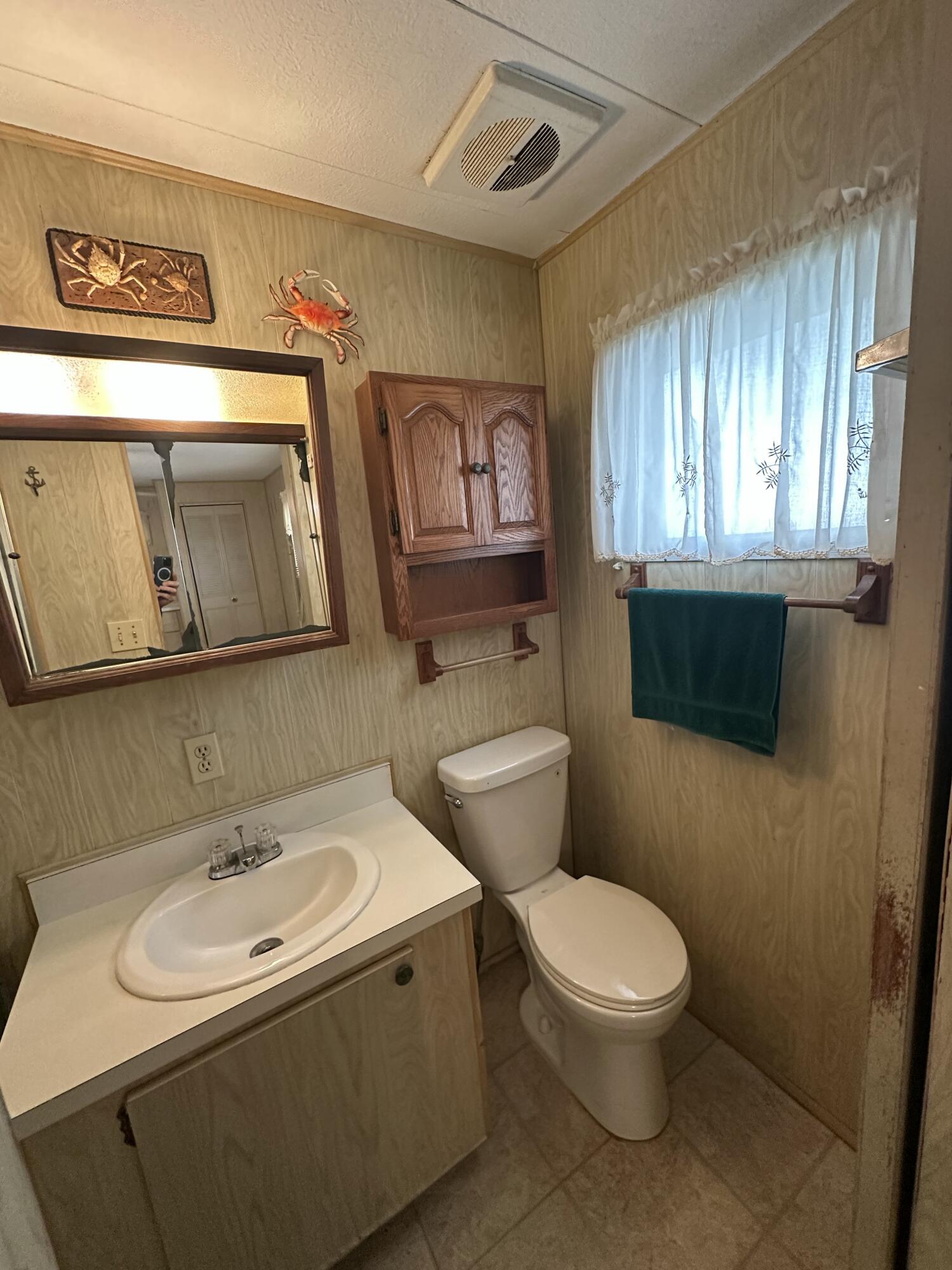 8435 East Club Road Boca Raton, FL 33433 - Photo 18 of 31 a white toilet sitting next to a bathroom sink