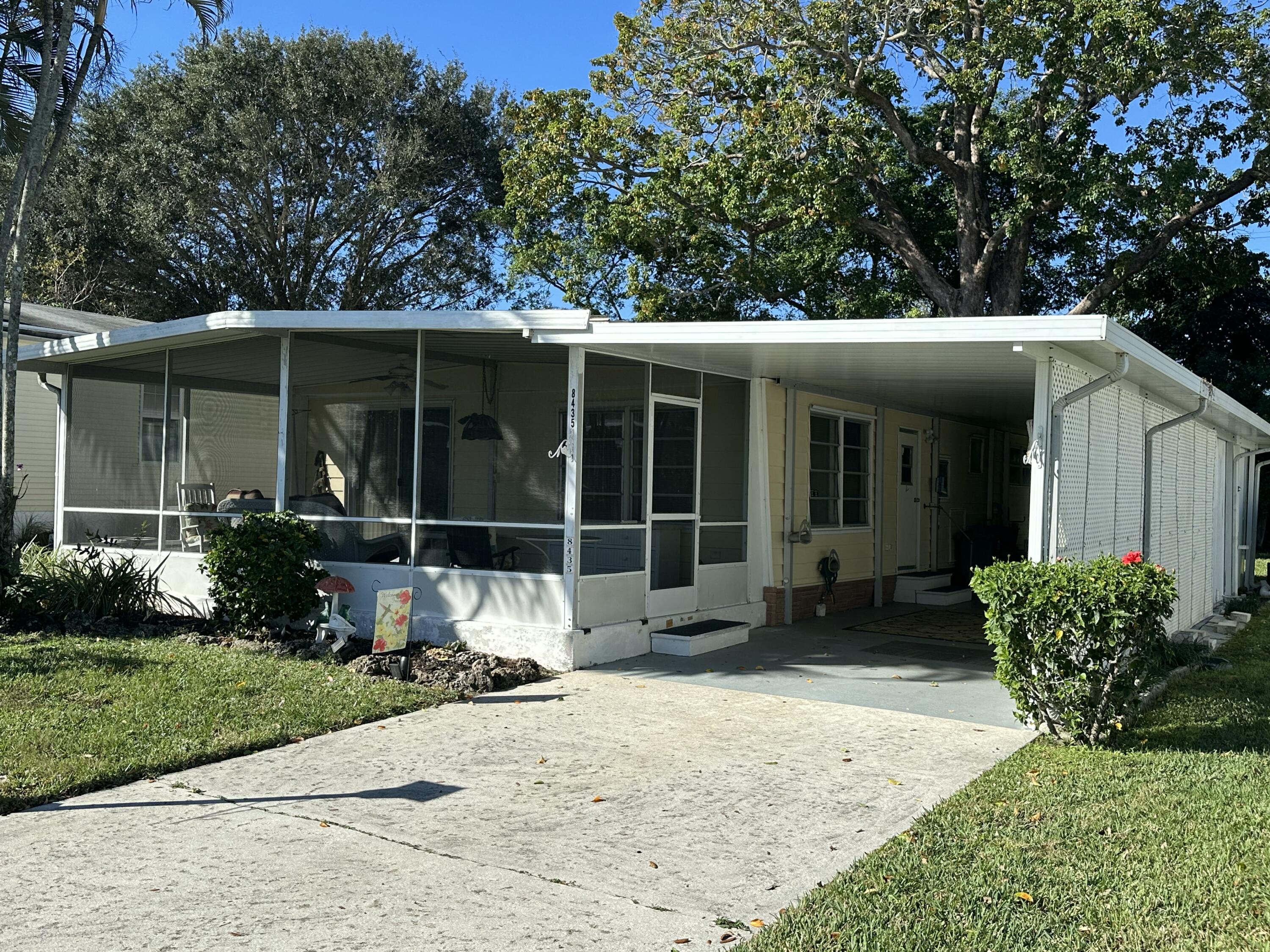 8435 East Club Road Boca Raton, FL 33433 - Photo 3 of 31 a front view of a house with a yard and potted plants