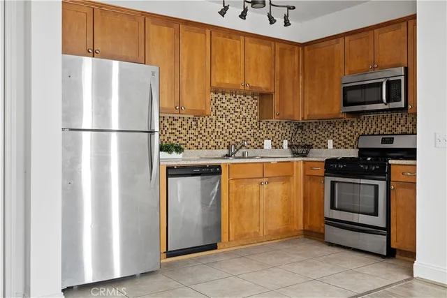a kitchen with stainless steel appliances granite countertop a refrigerator and a stove