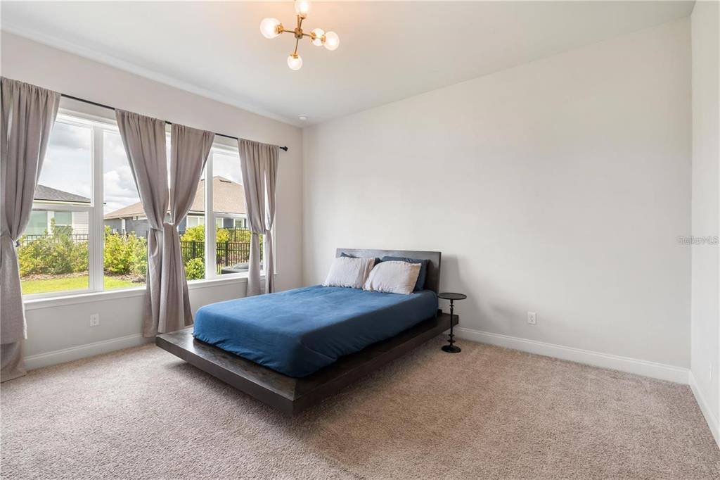 3225 Southwest 120th Terrace Gainesville, FL 32608 - Photo 12 of 42 a bed sitting in a spacious bedroom next to a window