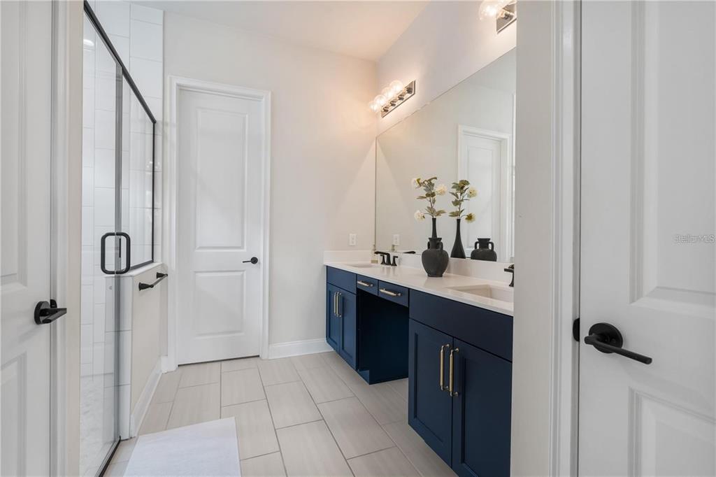 3225 Southwest 120th Terrace Gainesville, FL 32608 - Photo 15 of 42 a spacious bathroom with a double vanity sink a mirror and a shower