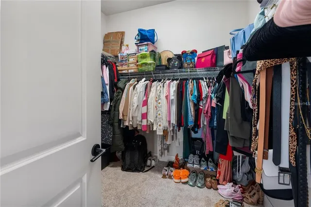a view of walk in closet with clothes