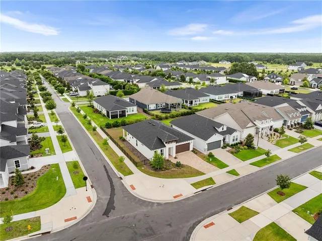 an aerial view of residential houses with outdoor space and swimming pool