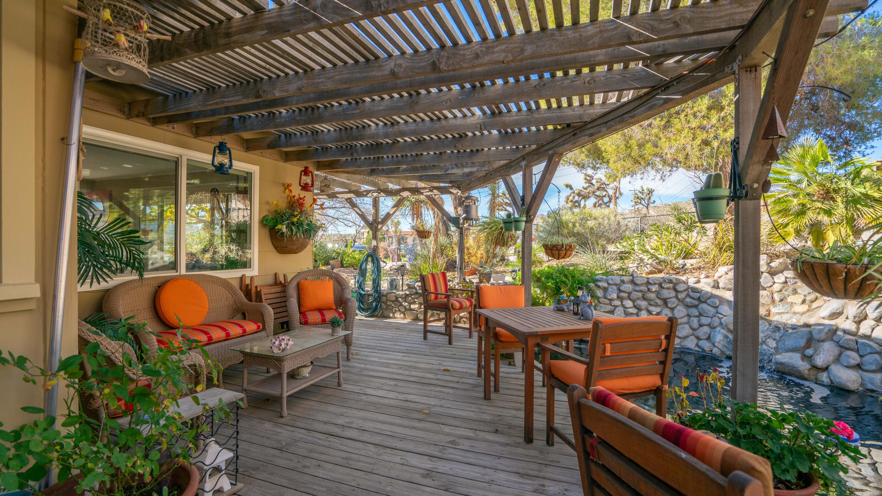 6913 Apache Trail Yucca Valley, CA 92284 - Photo 27 of 45 an outdoor sitting area with furniture and wooden floor