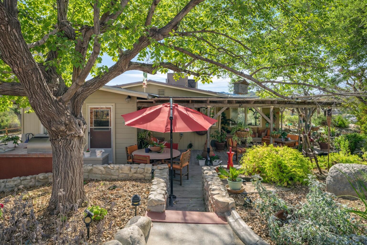 6913 Apache Trail Yucca Valley, CA 92284 - Photo 33 of 45 a patio with a table and chairs under an umbrella