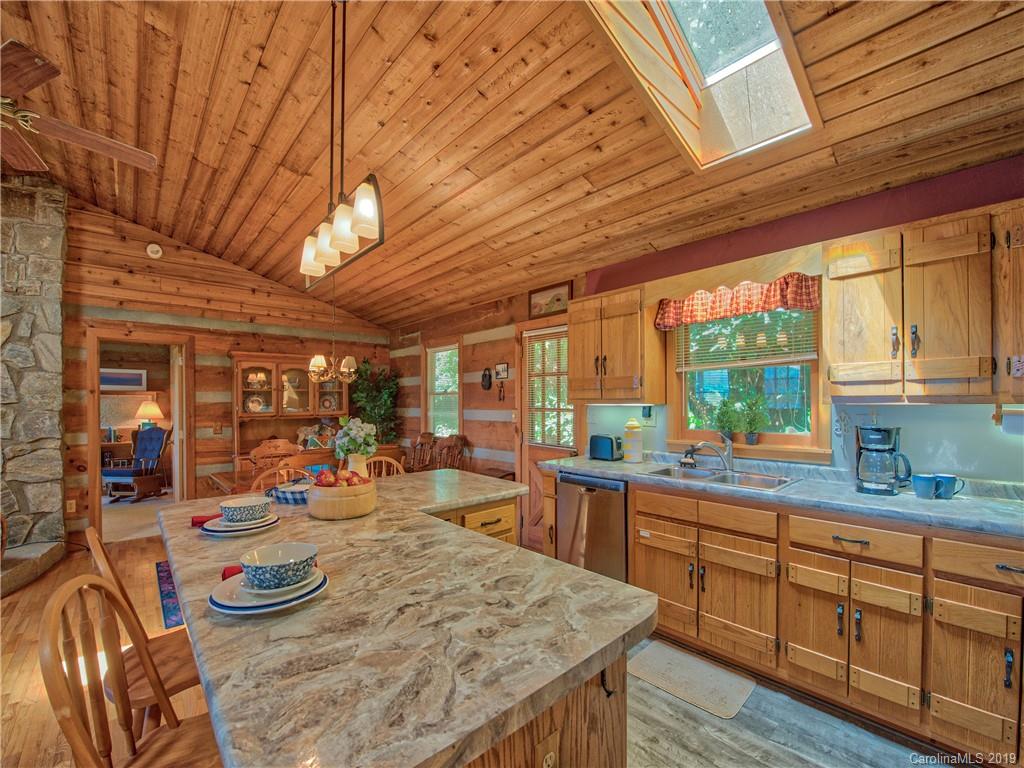 949 Setzercove Road Maggie Valley, NC 28751 - Photo 17 of 31 a kitchen with stainless steel appliances wooden floor wooden cabinets and dining table