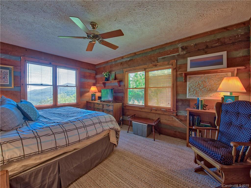 949 Setzercove Road Maggie Valley, NC 28751 - Photo 21 of 31 a bedroom with a bed wooden floor and window