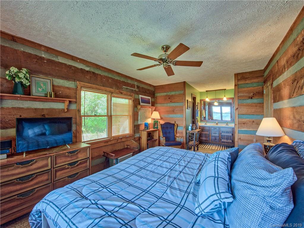949 Setzercove Road Maggie Valley, NC 28751 - Photo 23 of 31 a bed room with a bed mirror and window