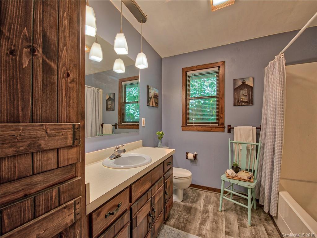 949 Setzercove Road Maggie Valley, NC 28751 - Photo 31 of 31 a spacious bathroom with a sink a toilet and a mirror