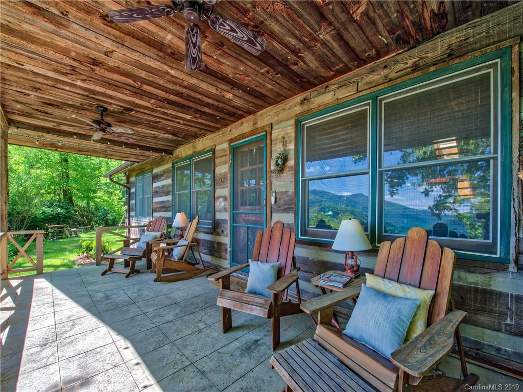 949 Setzercove Road Maggie Valley, NC 28751 - Photo 5 of 31 a outdoor space with patio the couches and a dining table and chairs with the view of garden