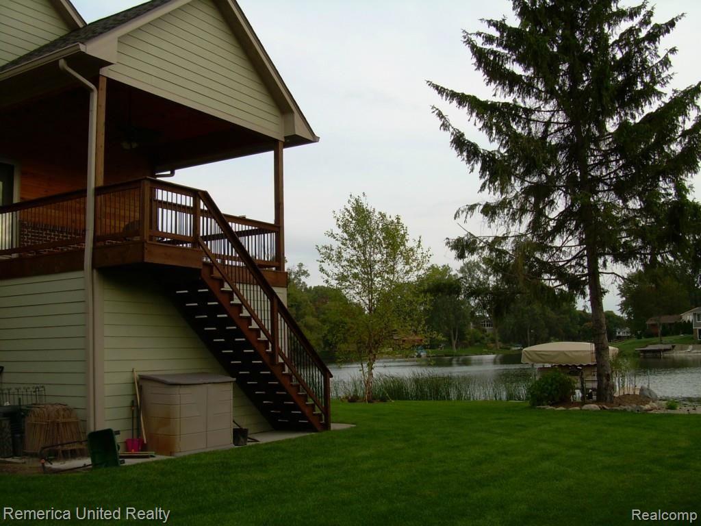3467 East Commerce Road Commerce Township, MI 48382 - Photo 3 of 36 Side yard with view of upper level deck off Master Suite and under deck storage.