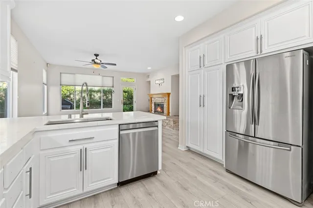 a kitchen with stainless steel appliances wooden floor and a refrigerator