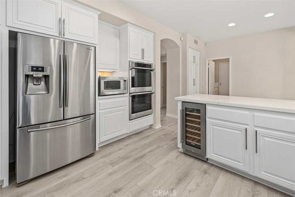 27806 Homestead Road Laguna Niguel, CA 92677 - Photo 15 of 52 a kitchen with stainless steel appliances wooden floor and a refrigerator
