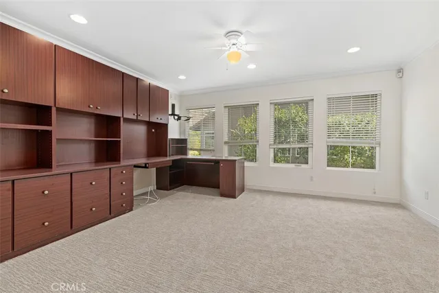 an empty room with windows and ceiling fan