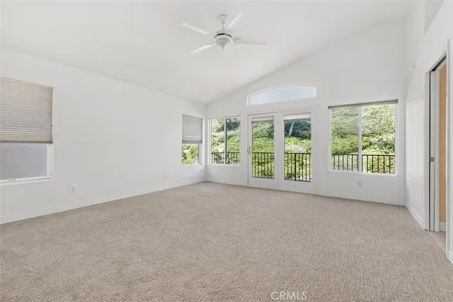 a view of a big room with windows and chandelier fan