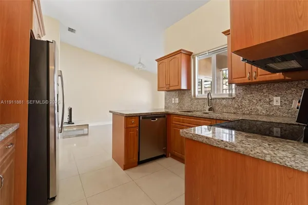 a kitchen with stainless steel appliances granite countertop a refrigerator and a sink