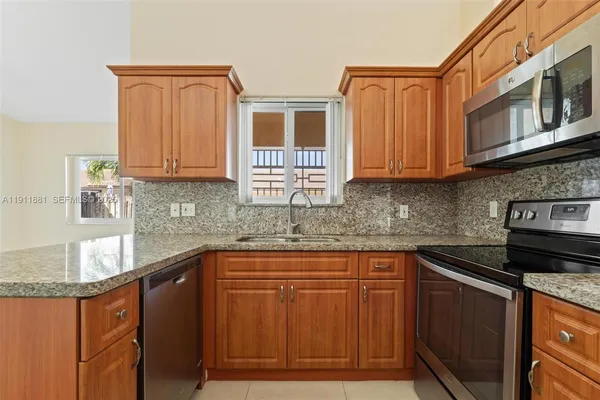a kitchen with stainless steel appliances granite countertop a sink stove and microwave