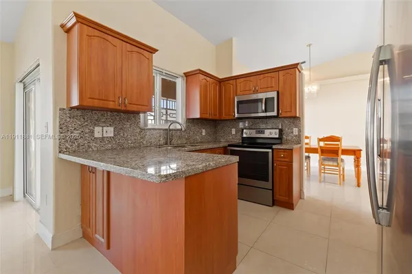 a kitchen with stainless steel appliances granite countertop a stove a sink and a microwave