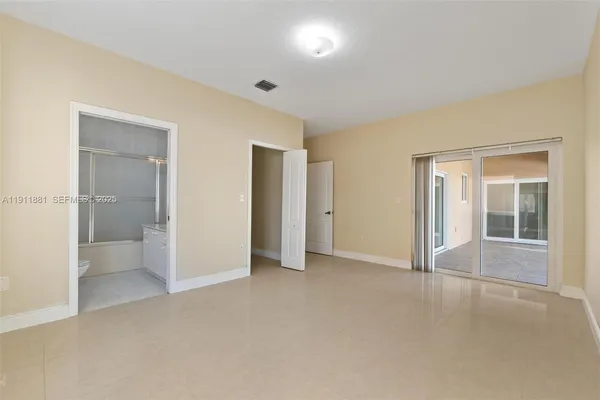 an empty room with a bathroom and mirror