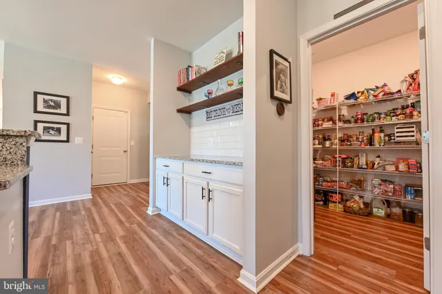 a view of a hallway with wooden floor and cabinets