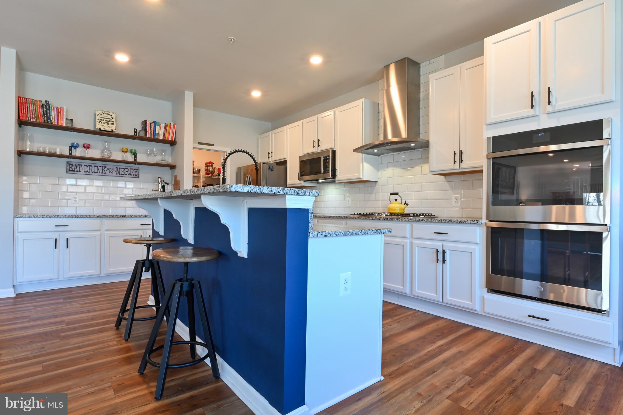 5559 Trafalgar Circle Tilghman, MD 21671 - Photo 16 of 62 a kitchen with stainless steel appliances granite countertop a stove top oven a sink dishwasher and cabinets with wooden floor