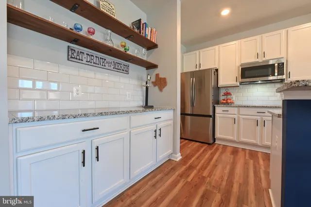 a kitchen with stainless steel appliances a refrigerator sink and microwave