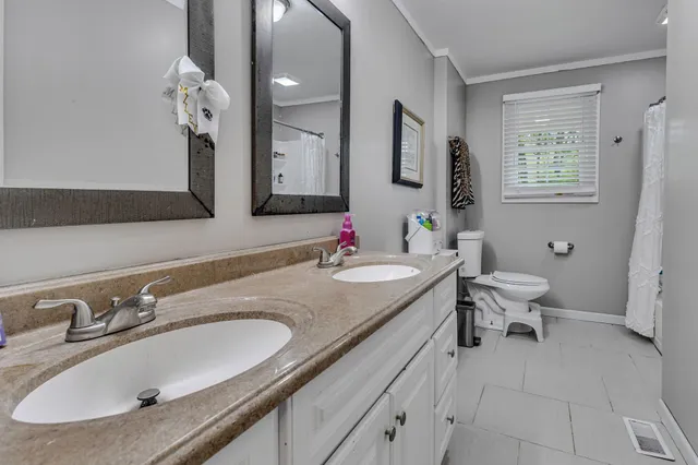 a bathroom with a granite countertop sink a mirror and a toilet