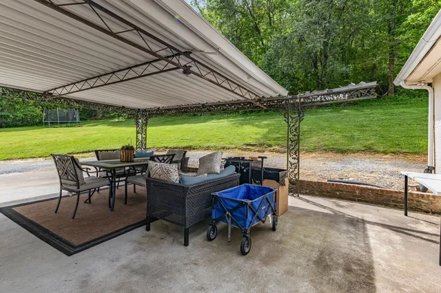 a view of a swimming pool with a table and chairs under an umbrella