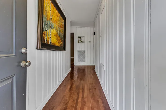 a view of a hallway with wooden floor and windows