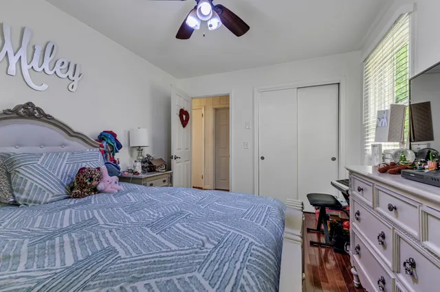 a bedroom with a bed and a flat tv screen on the dresser