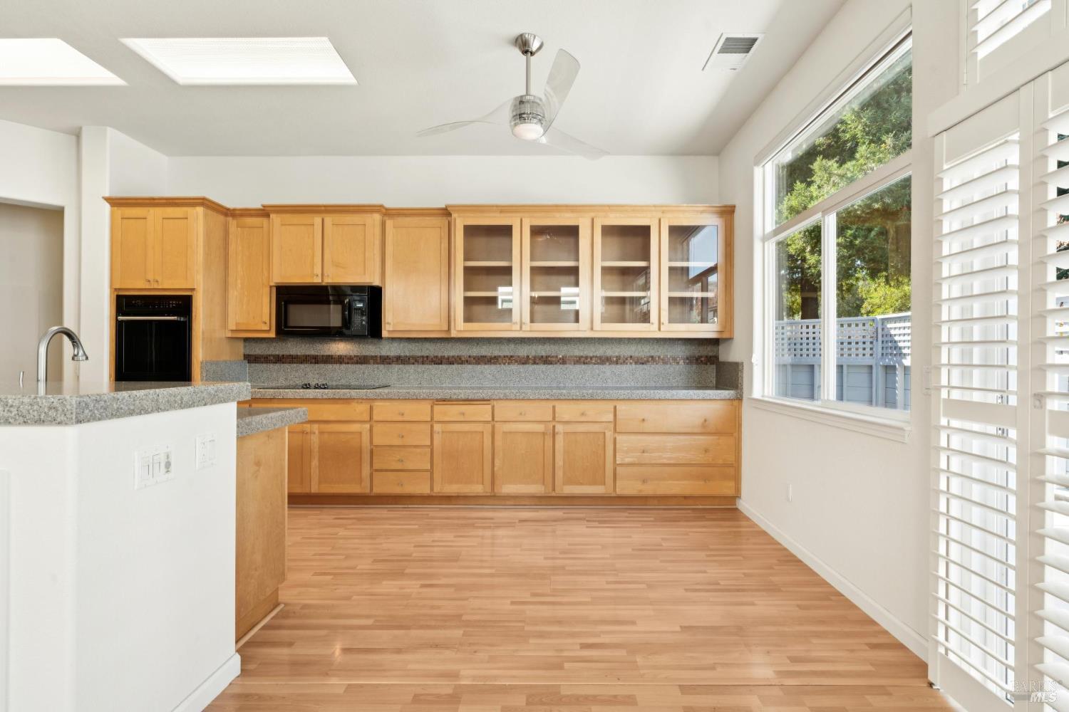 6471 Pine Valley Drive Santa Rosa, CA 95409 - Photo 7 of 48 a large white kitchen with granite countertop a stove a sink and a microwave