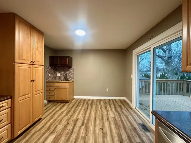 a kitchen with a refrigerator stove and wooden floor