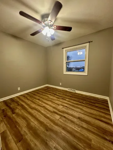 a view of an empty room with a chandelier fan