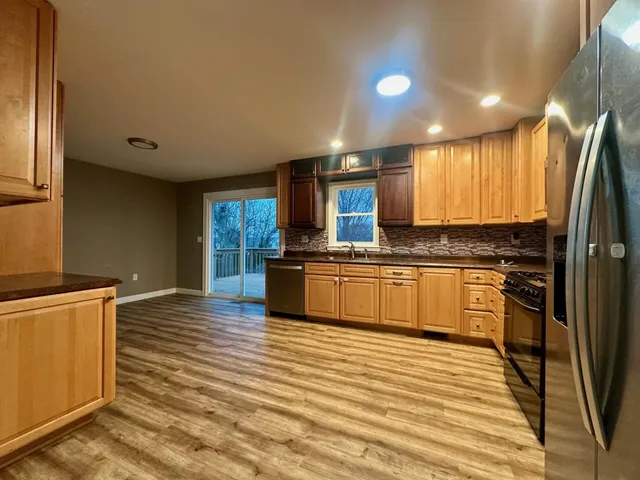 a large kitchen with kitchen island a sink stainless steel appliances and cabinets