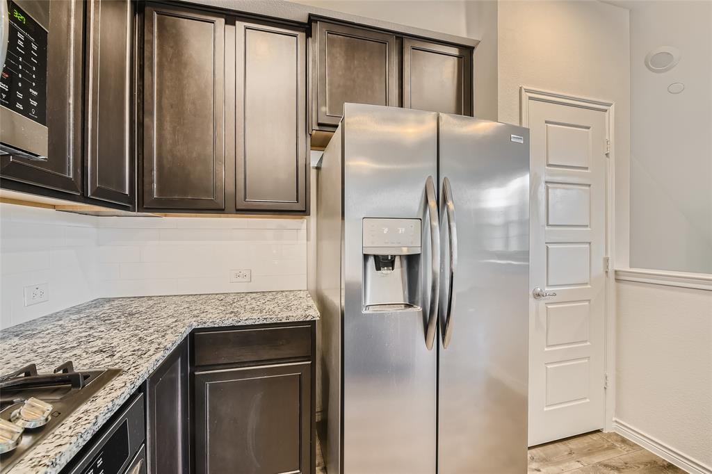 2407 Siskiyou Street Lewisville, TX 75056 - Photo 12 of 31 a kitchen with granite countertop a refrigerator and a stove