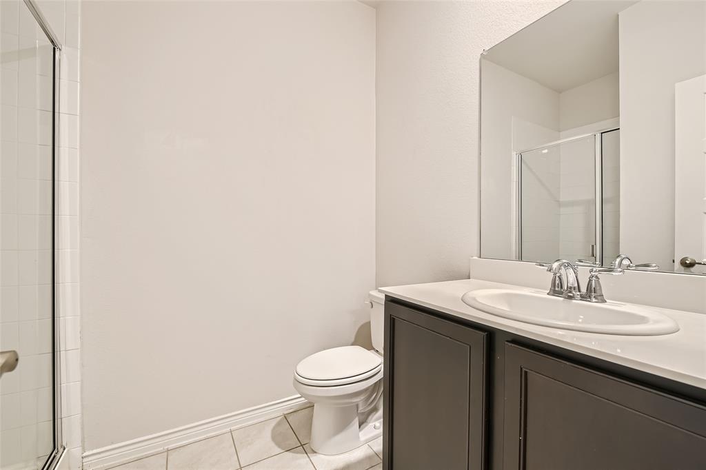2407 Siskiyou Street Lewisville, TX 75056 - Photo 17 of 31 a bathroom with a sink a toilet and mirror